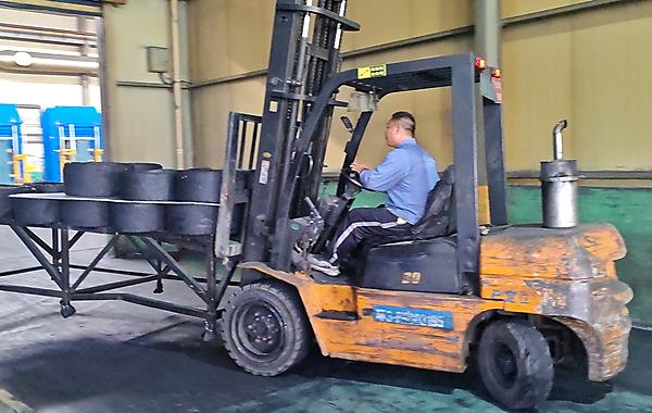Forklift transporting solid tyre blanks inside JABIL production facility